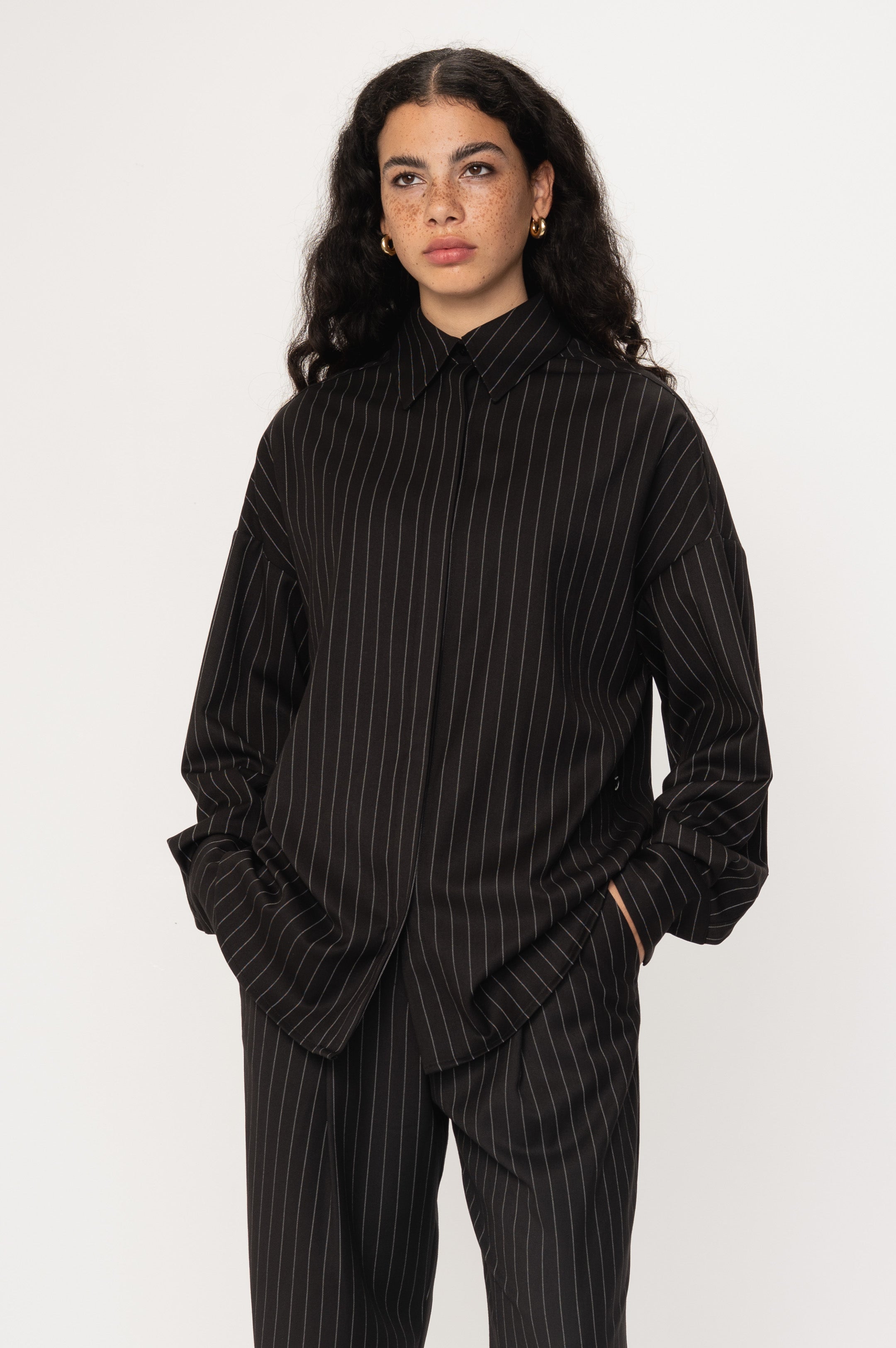 VIVEH Thuban top in Black Pinstripe – '- heavy woven pinstripe blouse with timeless, elevated appeal – front view